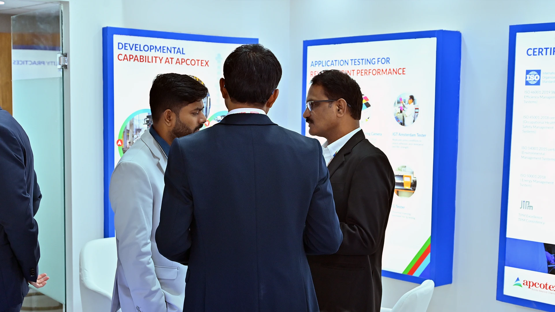 Apcotex team explaining application testing and development capabilities at Paperex 2025 using structured brand communication panels.
