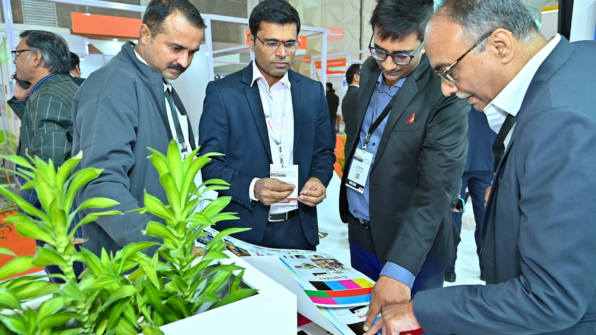 B2B stakeholders reviewing product samples and visual material at the Apcotex Paperex 2025 exhibition stall.